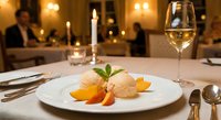 Elegant gourmet dessert with ice cream and orange slices served on white plate in upscale restaurant with wine glass and candlelit ambiance for fine dining.