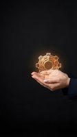 Hand holding glowing golden gear hologram representing innovation, technology solutions, and digital transformation in business automation.