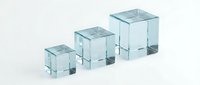 Three transparent glass cubes of increasing size arranged in a row, isolated on white background, suitable for design projects, packaging mockups, and commercial applications.