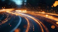 Glowing orange light trails with sparkling particles create dynamic motion effect against dark background. Abstract energy streams flow with bokeh elements.
