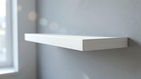 Modern white floating shelf mounted on gray wall near window with soft natural lighting for minimalist home decor and interior design solutions.