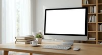 Modern workspace with blank computer monitor on wooden desk, coffee cup, books and plant in bright home office with bookshelf background for mockup designs.