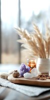 Healing crystals and pampas grass arrangement on wooden tray with essential oil bottle and dried herbs. Cozy spiritual wellness setup for meditation and aromatherapy.