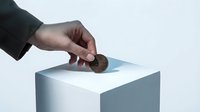 Male hand in business attire dropping coin into white box slot, representing donation, charity, savings, investment, or financial contribution concept for commercial use.