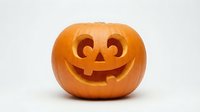 Carved orange pumpkin jack-o-lantern with smiling face isolated on white background for Halloween decorations and autumn seasonal designs.