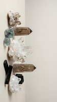 Collection of healing crystals and gemstones arranged on neutral background for spiritual wellness meditation and energy work practices.