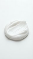 Creamy white cosmetic product with smooth, swirled texture isolated on white background for skincare, beauty, and wellness design applications.