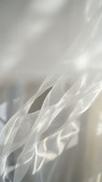 Soft white flowing fabric with delicate folds and gentle lighting creates ethereal textile background for wedding and fashion design projects.