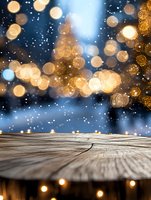 Rustic wooden table surface against magical winter bokeh background with golden lights and falling snow, creating cozy holiday atmosphere for product display.