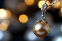 Elegant golden pearl pendant with diamond accents on silver chain against soft bokeh background, showcasing luxury jewelry details and craftsmanship.