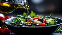 Fresh Mediterranean salad with olive oil being poured from bottle, cherry tomatoes and green herbs in dark bowl against black background. Food photography.