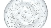 Close-up of water droplets and bubbles on a clear glass surface, ideal for backgrounds, skincare, cosmetics, and wellness product marketing.