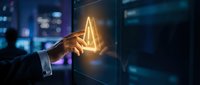 Businessman hand touching glowing triangle warning symbol on futuristic digital interface screen in modern office environment with blue technology background.