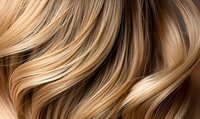 Flowing blonde hair waves with honey and caramel highlights creating dynamic movement pattern, close-up view showing luxurious healthy hair texture and shine.