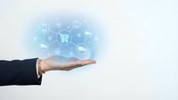 Hand of a male professional in dark business suit holding glowing digital shopping cart icon with connected e-commerce symbols, representing online retail and digital commerce solutions.