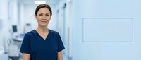 Professional female healthcare worker in navy scrubs standing in modern medical facility with blank digital display screen for custom messaging.