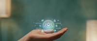 Young adult hand holding glowing digital shield with security icon and data network symbols, representing cybersecurity protection and technology safety solutions.