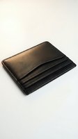 Compact black leather wallet with card slots isolated on white background, suitable for e-commerce, product photography, fashion accessories, and retail design applications.