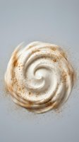 Creamy white swirl with cinnamon spice powder dusting on neutral background for culinary and dessert design projects.
