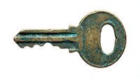Vintage bronze key with patina finish isolated on white background for antique security and lock concepts.