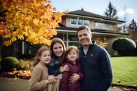 Happy family of four smiling outdoors in front of suburban house during autumn season with golden maple leaves and manicured lawn in background.