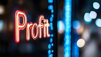 Glowing red neon profit sign against dark background with blue bokeh lights creating modern business atmosphere and financial success concept.