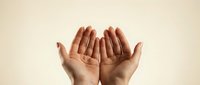 Open cupped hands gesture on neutral background showing palms in receiving or offering position for prayer meditation and spiritual concepts.