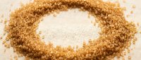 Brown sugar granules arranged in a circle with white sugar in the center on neutral background, suitable for food styling and culinary design projects.