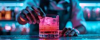 Bartender preparing pink cocktail at neon-lit bar counter with ice cubes in crystal glass. Atmospheric nightclub setting with turquoise and magenta lighting creates moody ambiance.