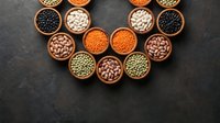 Assorted legumes and pulses in wooden bowls arranged in heart shape on dark slate surface for healthy eating and nutrition concepts.