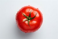 Fresh ripe red tomato with water drops and green stem on white background, isolated macro shot for food packaging and advertising design.
