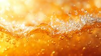 Energetic splash of carbonated drink with bubbles and droplets on golden orange background with bokeh effect, macro photography closeup view.