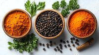 Aromatic spices in wooden bowls - turmeric, black peppercorns and paprika powder with fresh parsley leaves and cinnamon stick on white background. Food seasoning.