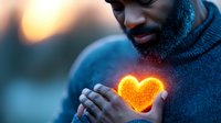 African American man in blue sweater holding glowing orange heart light against blurred evening background, expressing warmth and emotional connection.