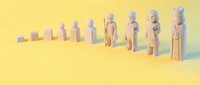 Wooden toy figures arranged in ascending size order on yellow background showing growth progression and development concept for business presentations.