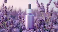 Purple essential oil dropper bottle surrounded by blooming lavender flowers in soft focus. Natural aromatherapy and organic skincare concept for wellness and spa.