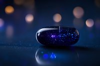 Magical glowing capsule with sparkling blue particles inside on dark reflective surface against blurred bokeh background creates mystical atmosphere.