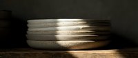 Stack of metallic bangles with brushed silver finish catching warm light, arranged on wooden surface for jewelry, fashion, and accessory design projects.