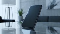 Modern smartphone with blank black screen on reflective glass surface in contemporary office interior with minimalist decor and natural lighting.
