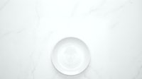 Empty white ceramic bowl on marble surface, isolated on clean background, ready for food styling, product mockup, and design projects.