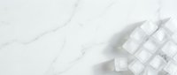 Overhead view of white sugar cubes scattered on marble surface with copy space for food and beverage design projects.
