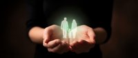 Cupped hands holding glowing silhouettes of man and woman representing family protection, life insurance, healthcare coverage and human care services.
