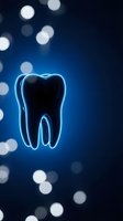 Glowing neon tooth outline on dark blue background with bokeh lights for dental care and oral health concepts.