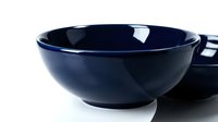 Deep navy blue ceramic bowls with glossy finish on white background, showcasing elegant kitchenware for food styling and product photography.