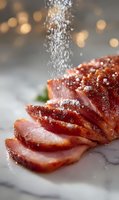 Sliced smoked ham with salt falling from above on marble surface against blurred bokeh background. Close-up view of juicy meat with seasonings.