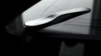 Modern curved architectural element with flowing lines and dramatic lighting creating elegant shadows on textured surface for contemporary design projects.