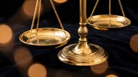Golden scales of justice with warm bokeh lights creating elegant legal concept for law firm branding and judicial system representation.