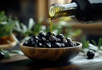 Golden olive oil pouring from bottle into wooden bowl filled with fresh black olives, creating gourmet Mediterranean culinary scene.