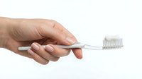Hand holding clear toothbrush with soft bristles on white background, isolated for dental hygiene, oral care product design, and healthcare marketing materials.