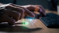 Hands touching keyboard with glowing digital hologram overlay showing financial charts, graphs and data analytics for business technology and digital transformation concepts.